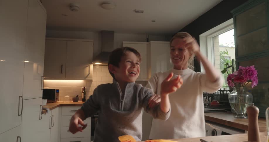 Mother and son in the kitchen playing and cooking affectionately