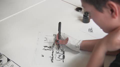 A woman draws with a pen