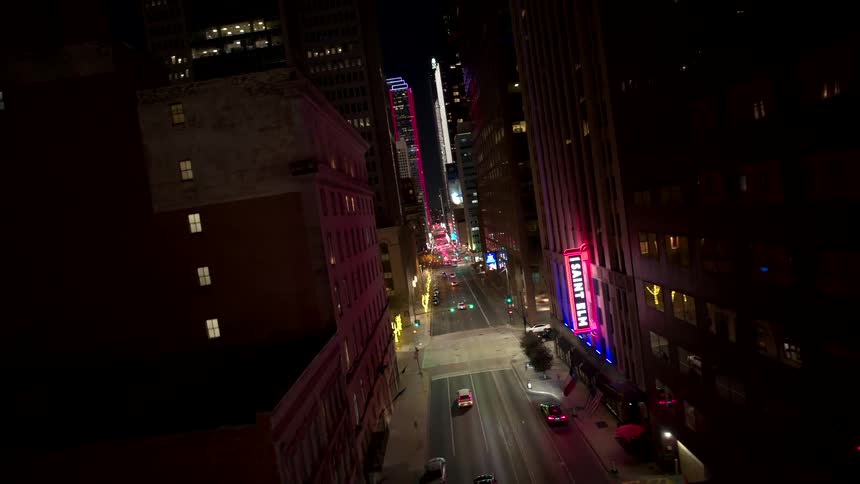 Nighttime cityscape with illuminated streets and moving vehicles