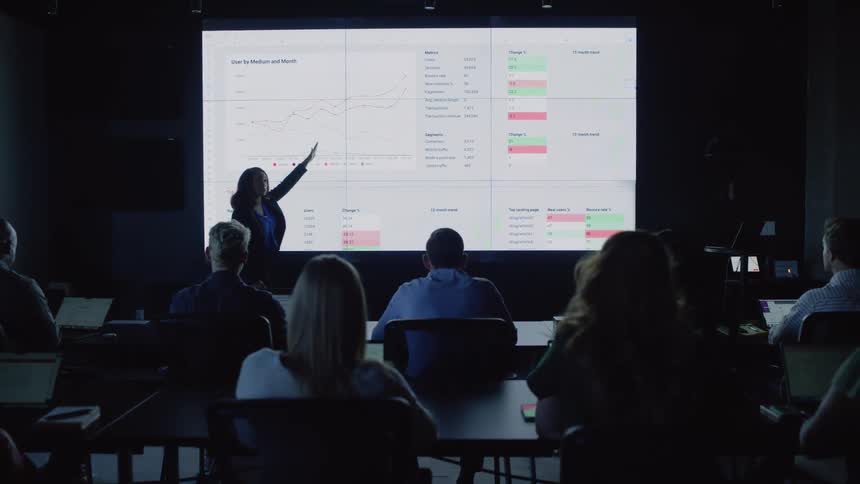Woman presenting an infographic in an auditorium to a group of people