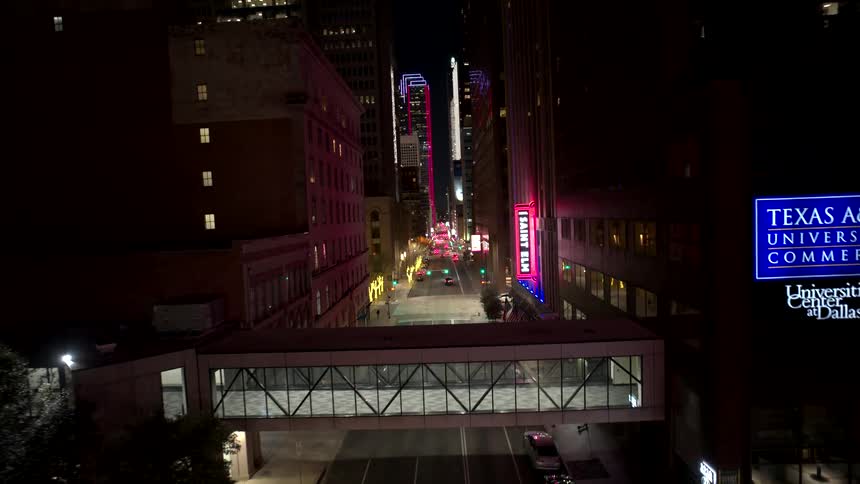 Night aerial view of a city street with illuminated signs