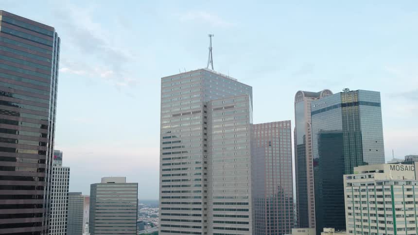 Skyline view of a modern city with numerous high rise buildings under a blue sky