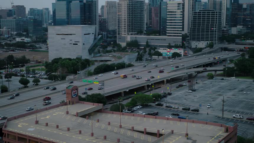 Aerial view of a busy highway in the city during twilight with multiple highrise buildings