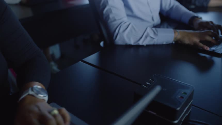 A group of people working side by side on laptops