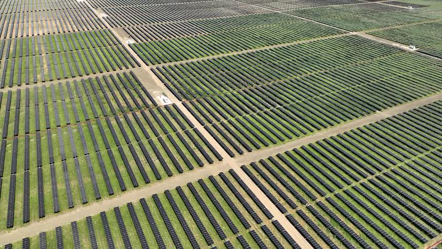 Aerial view of a large field with several standardized solar panels