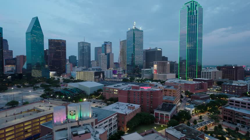 Cityscape during twilight with illuminated buildings against a dusky sky