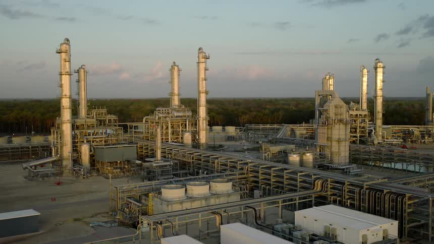 An industry with several metal towers and some metal pipes scattered around