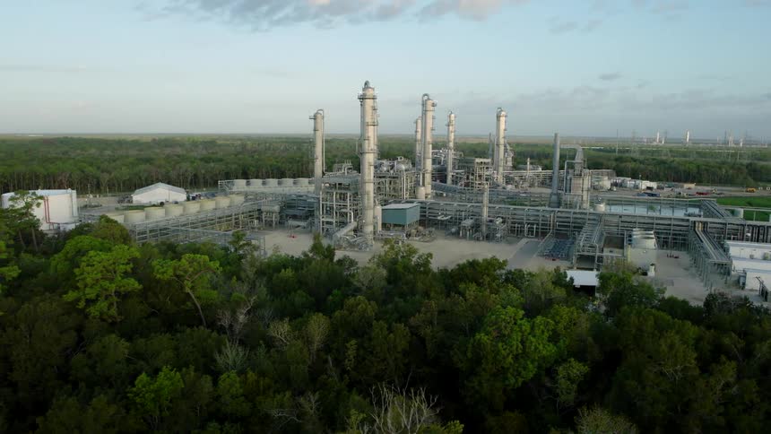Aerial view of a factory and refinery surrounded by trees