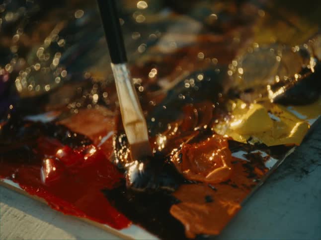 Close up of a palette with paint and a brush