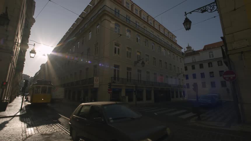 Street with a yellow tram and cars in an urban city with buildings lining the street