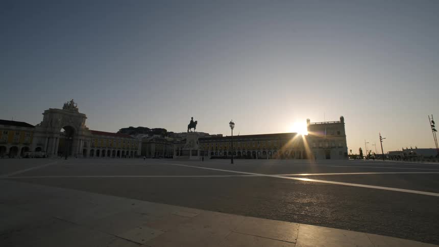 Town square with historic buildings and sunrise on the horizon