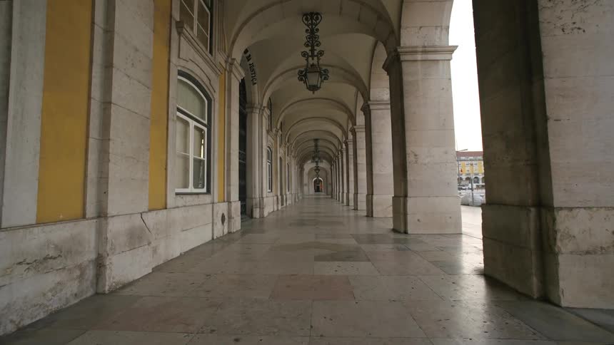 Long corridor with arched openings on one side and a solid wall on the other