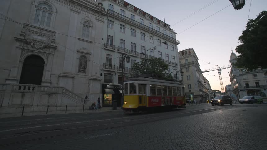 Street of a metropolis with classic buildings and vehicle traffic and a public tram