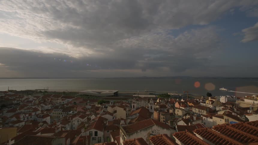Panoramic view of a coastal town under a cloudy sky with buildings densely clustered near the water