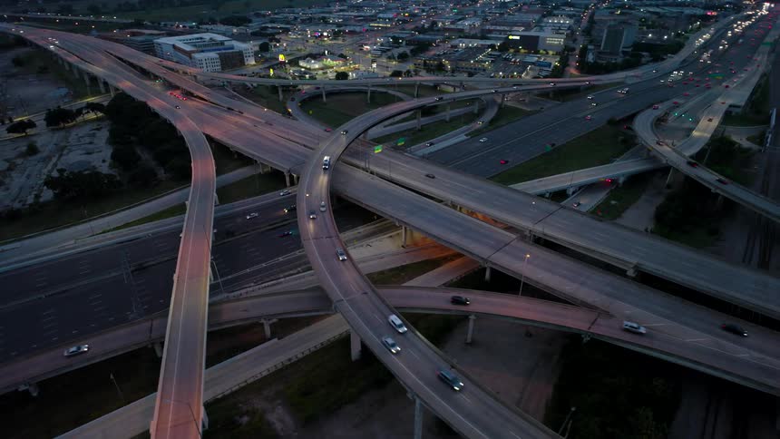 Aerial view of an overpass and intersections with vehicle traffic through a metropolis at night