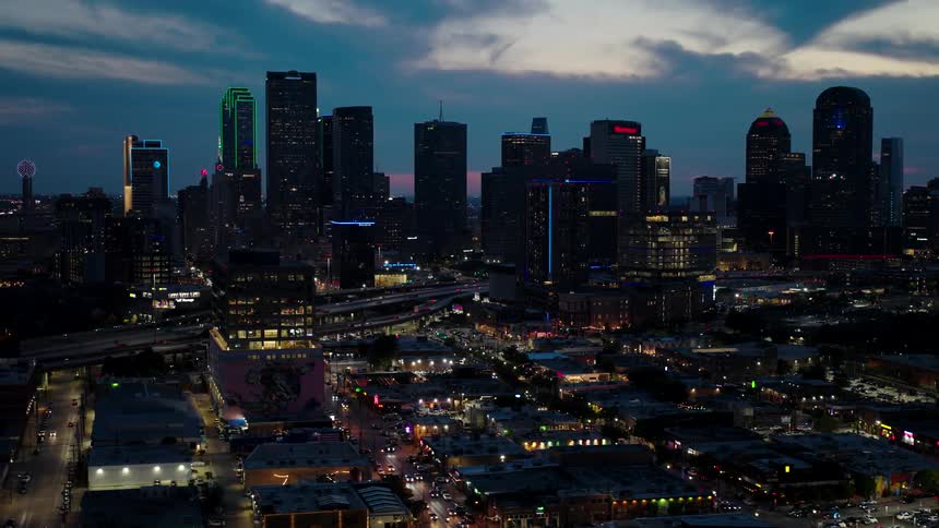 A city skyline during twilight with illuminated buildings and streets
