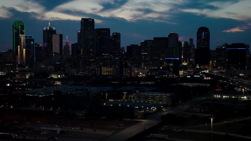 Panorama of a metropolis with modern skyscrapers seen at night and in the foreground intersections with vehicle traffic