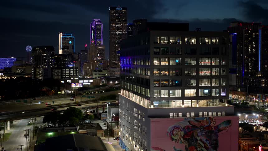 Modern metropolis with skyscrapers and a viaduct in the background with vehicle traffic seen at night
