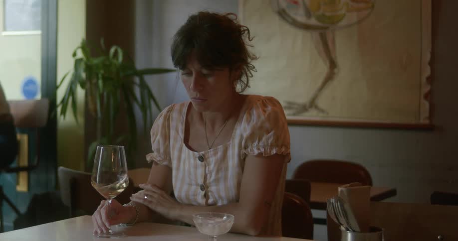 Woman sitting on a rocking table and a glass of white wine