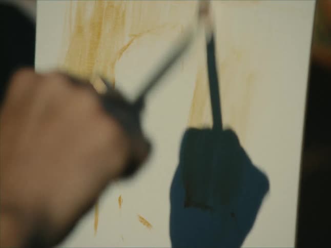 Artist casts a shadow on canvas while painting