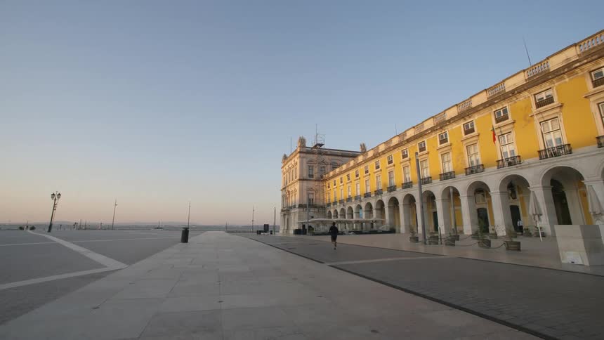 Classical building in a square and a person running in a morning