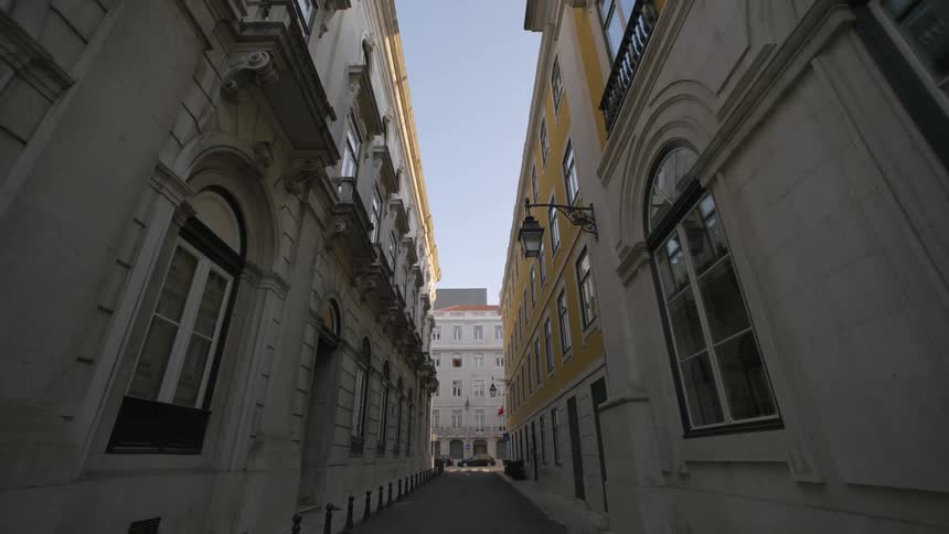 Narrow street is lined with tall buildings with classical architectural details