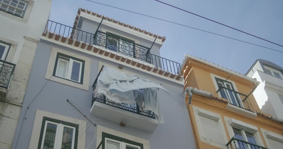 View up of residential buildings with one of them having sheets and towels hanging on the balcony