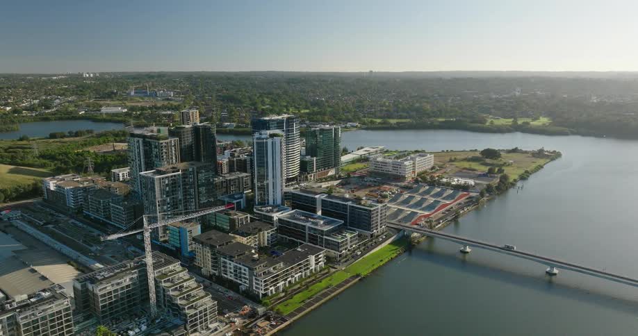Aerial view of a modern urban development next to a body of water with several tall buildings