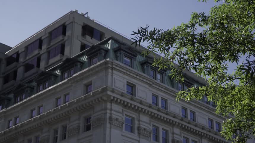Upper floors of a classical architecture building with a clear sky in the background