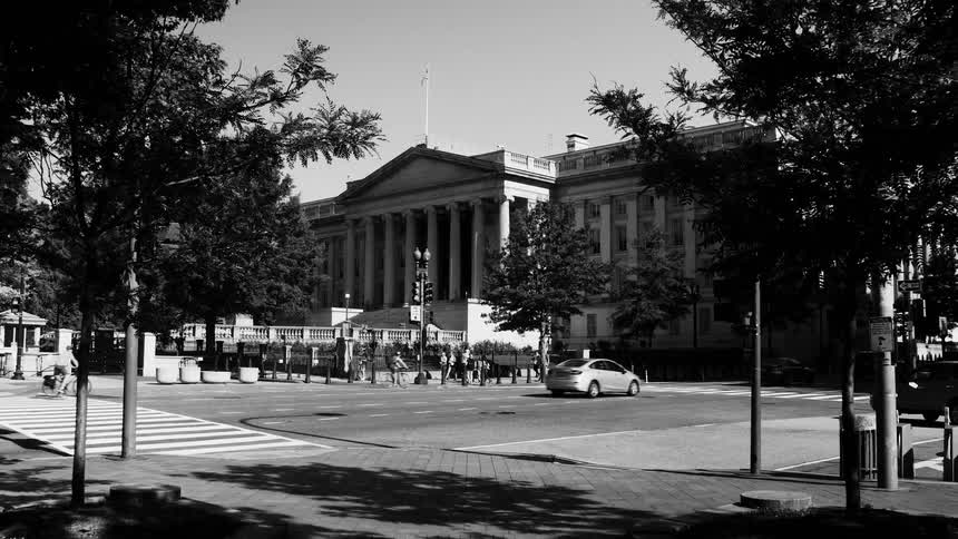 Urban scene with a classical building in the background with columns trees lining the street