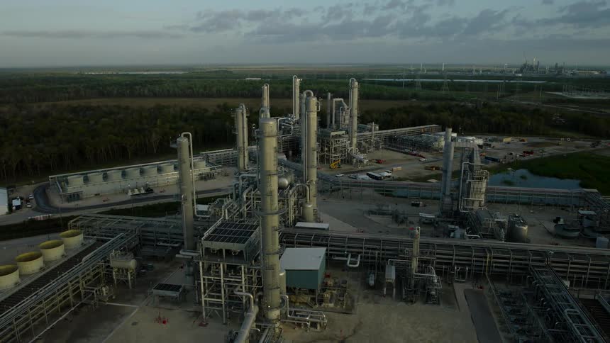 Aerial of a manufacturing plant surrounded by woods on a cloudy day