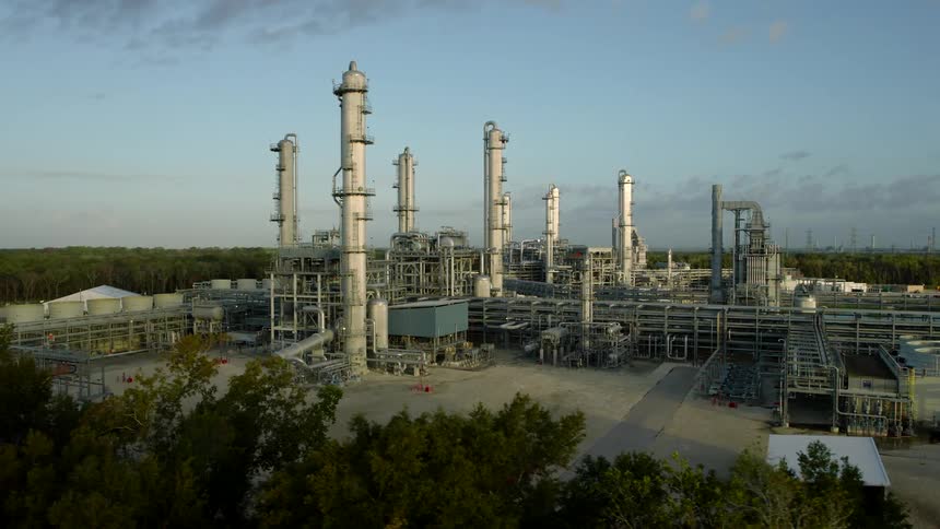 Large industrial facility with several tall distillation columns and an extensive pipeline network