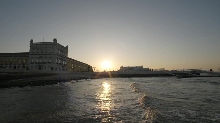 Seascape with classical buildings and sunrise in the background