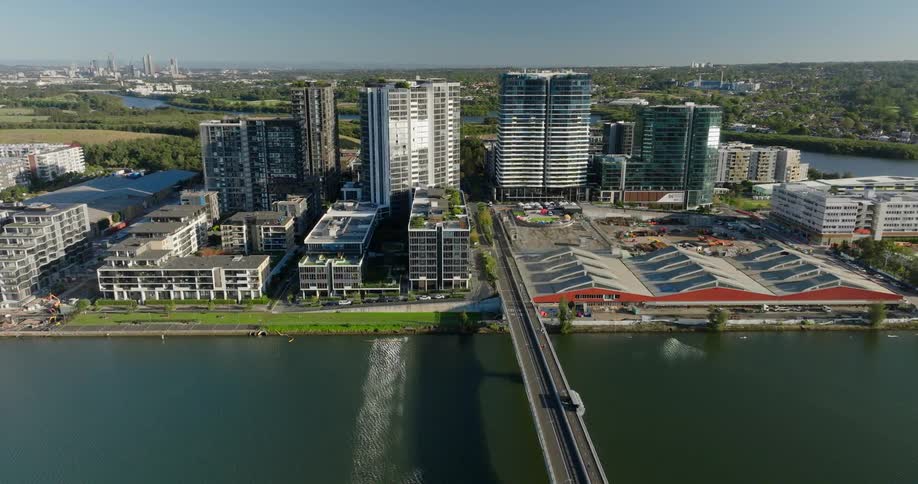 An aerial view of a modern urban waterfront development with multiple highrise buildings