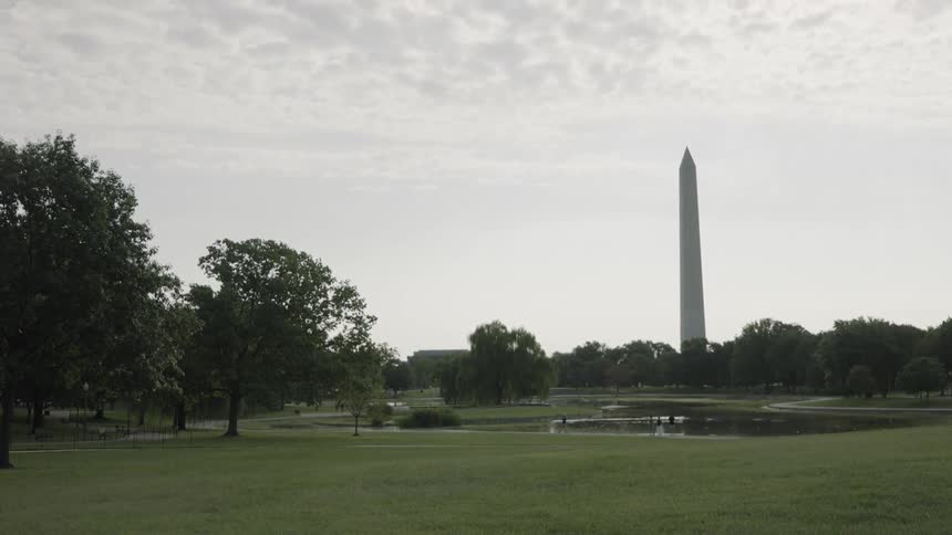 Square with a lake and a pillar in the background
