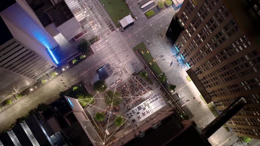 An aerial view of an urban location with some people walking and some buildings on the sides