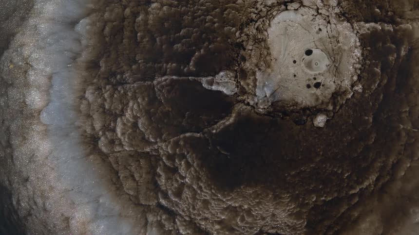 Layered mixture expands and collapses under a clear liquid