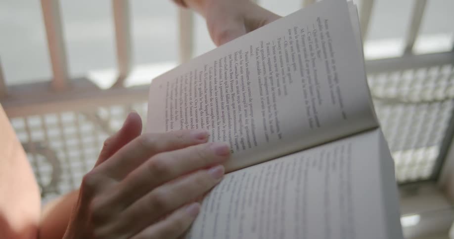 Hands of a woman turning the page of a book