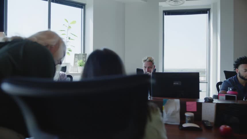 People in an office room on computers concentrating on working