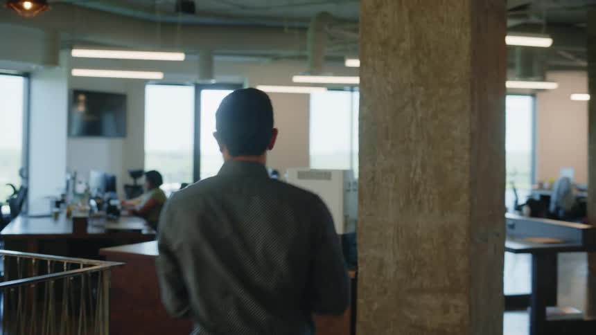 Interior of an office with people walking and others sitting and working