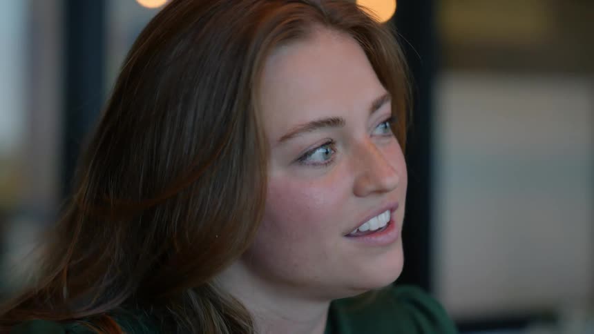 Side portrait of a woman sitting indoors talking