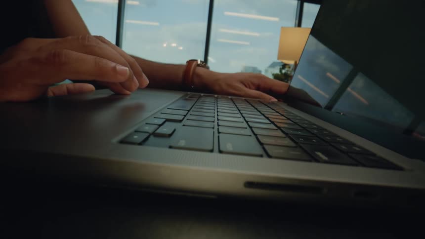 Hand scrolling on a laptop trackpad in an office setting