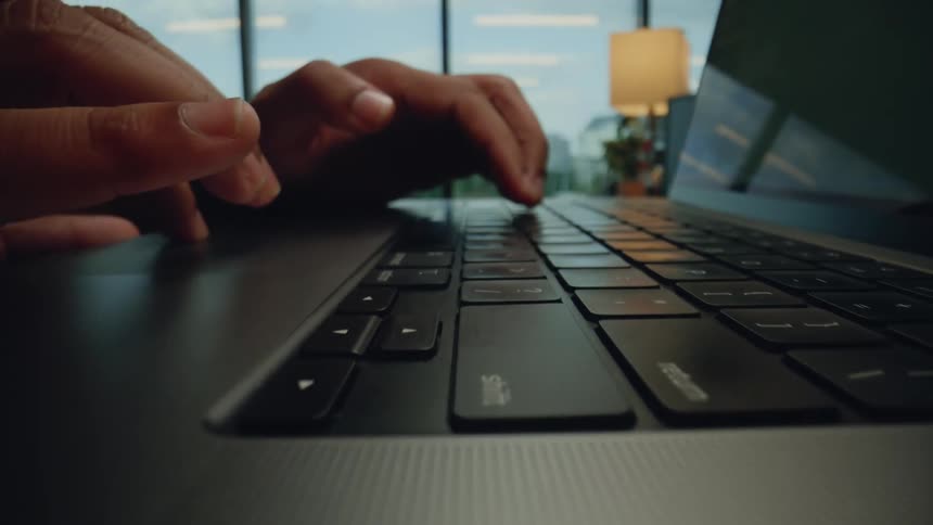 Hands of a man typing on a laptop on the table