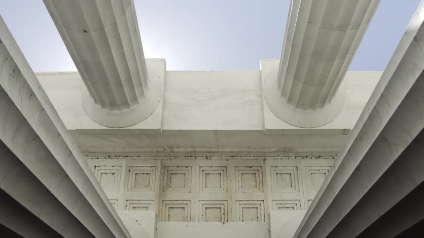 Upward view of white classical columns of a museum