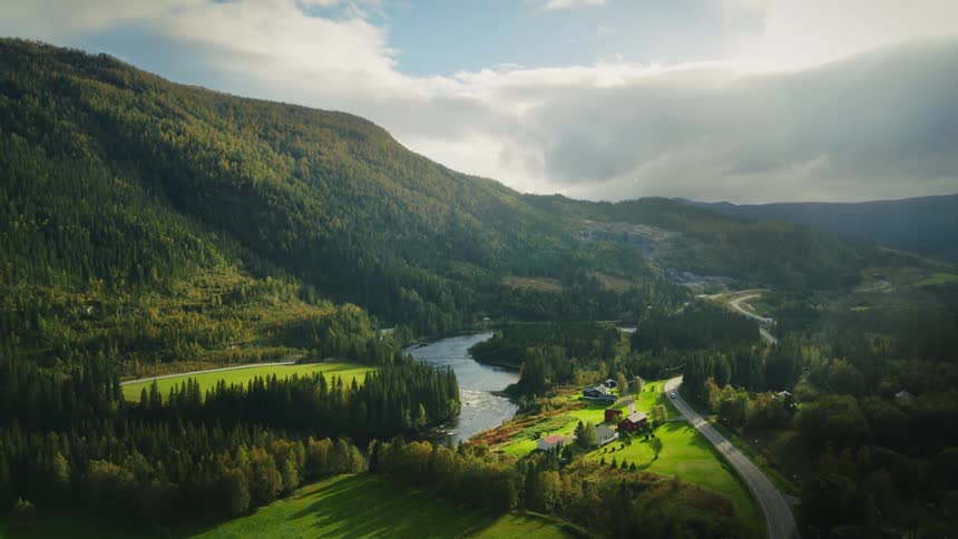 Aerial landscape of a mountain with forest by a lake on a cloudy day