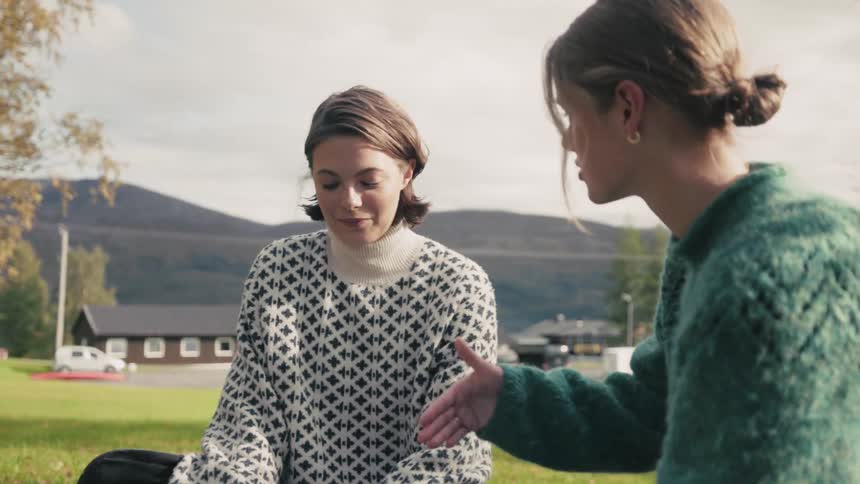 A clip of two females having a conversation out in the open nature