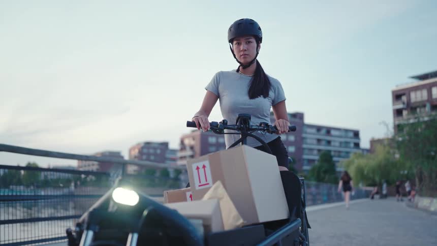 Delivery woman on an electric bike with packages
