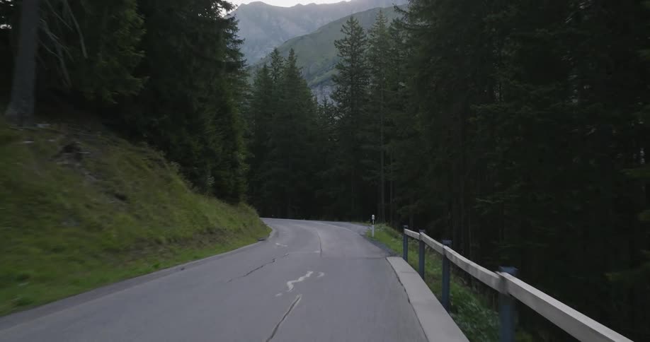 Highway passes through a conifer forest on a mountain on a hazy day