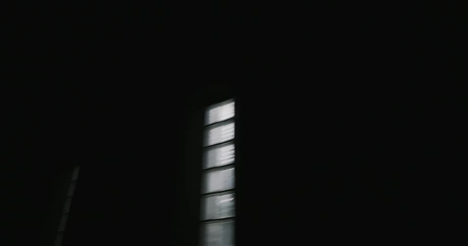The tunnel is dark and has windows on the wall