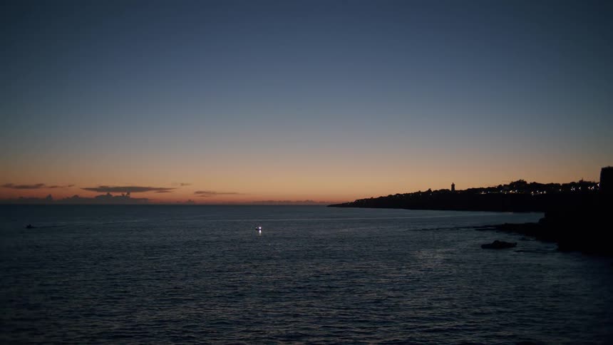 The sun is setting on the coast line